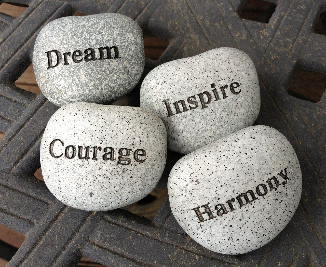 Dream, courage, inspire, harmony written on stones